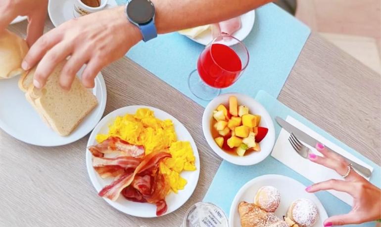 A man sitting at a table with dishes of food with a simple and hospitable charm.