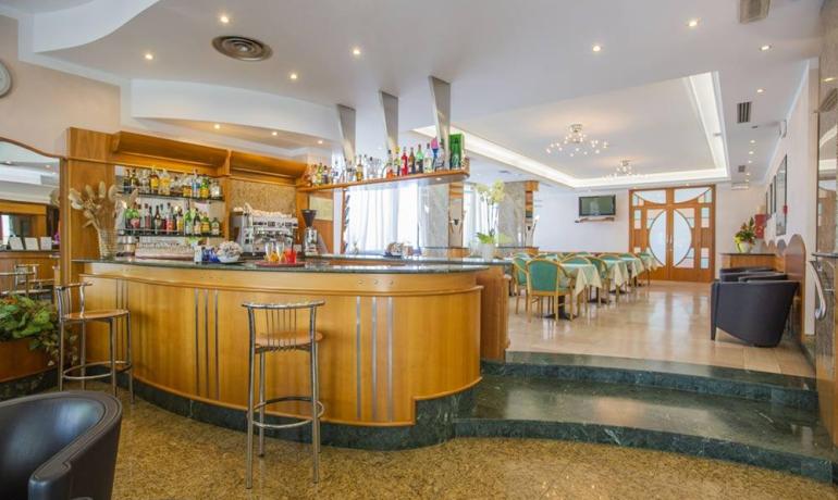 Elegante bar con sedie moderne, atmosfera accogliente e luci soffuse.
